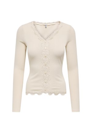 Langdurige mouw, geribbelde crèmekleurige top met een V-hals, voorzien van een centrale kantpaneel met knopen en een gegolfde kantafwerking langs de halslijn en de zoom.
