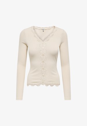 Maglia a maniche lunghe, in crema a coste, con scollatura a V, caratterizzata da un pannello centrale in pizzo con bottoni e bordatura in pizzo smerlato lungo il collo e l'orlo.