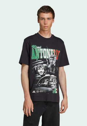 Black cotton t-shirt featuring a graphic print of Kimi Antonelli, with green and red accents and a car illustration. Short sleeves and crew neck.