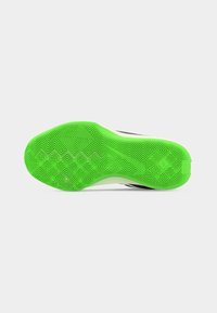 Jasnozielona, teksturowana gumowa podeszwa sportowego buta z geometrycznym wzorem bieżnika na jasnym tle.