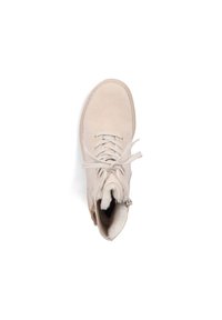 Bottine beige en suède doux, avec un design à lacets, doublure en fourrure et une fermeture éclair sur le côté pour un accès facile.