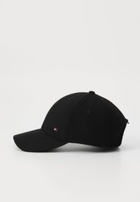Casquette de baseball noire en laine avec une visière incurvée, présentant un petit logo brodé à l'avant. Texture douce et design structuré.