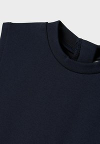 Marinblått, slätt tyg med rundad halsringning och förstärkt söm vid kragen. Minimalistisk design utan mönster eller detaljer.