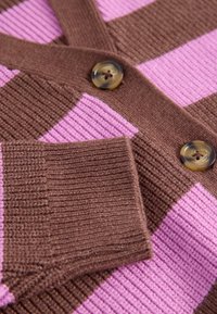 Brązowo-ró�żowy kardigan w paski z prążkowaną fakturą, z dwoma okrągłymi, marmurkowymi guzikami i dekoltem w serek.
