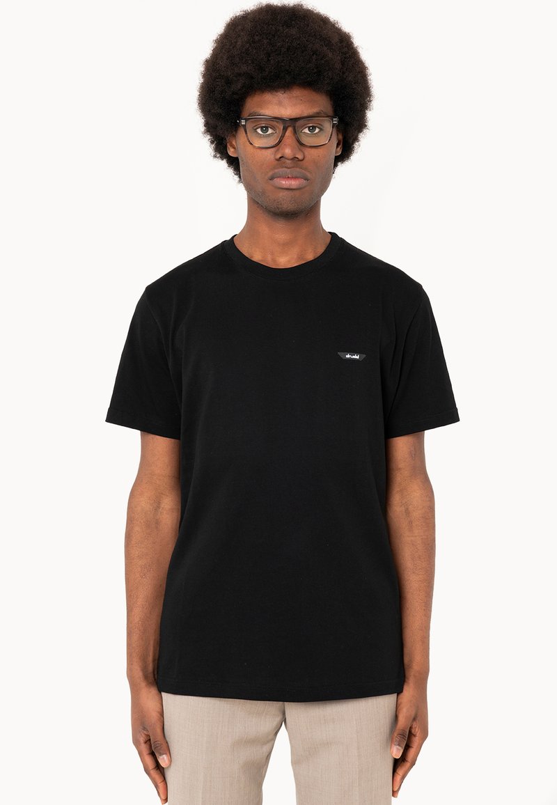 Black cotton t-shirt with a round neck, short sleeves, and a small logo patch on the left chest. Simple, classic fit design.