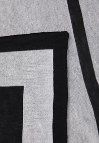 Sort-hvid tekstil med et geometrisk design, med markante, solide sorte kanter og en fin, struktureret vævning.