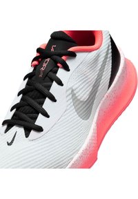 Sapatilha de corrida branca e preta com forro interior rosa, sola salpicada de rosa, atacadores pretos e logótipo Nike Swoosh cinza claro na lateral.