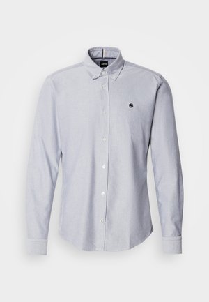 Camicia button-up azzurro chiaro con maniche lunghe, realizzata in un tessuto testurizzato. Presenta un piccolo logo sul lato sinistro del petto e polsini standard.