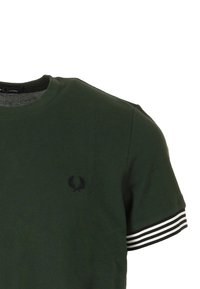 Maglietta a girocollo verde scuro con logo ricamato nero. Presenta dettagli a righe bianche sulle maniche e tessuto testurizzato.