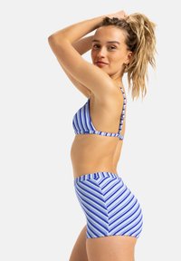 Blå og hvite stripete bikinitopp med tynne stropper, kombinert med høyhårede stripete truser. Glatt, elastisk materiale, uformell design.