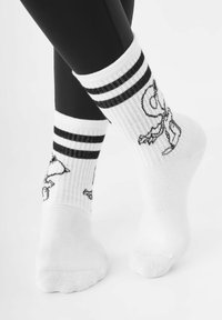 Weiße Baumwollsocken mit schwarzen Streifen und Cartoon-Charakterdesigns, gerippte Textur, mittellange Ferse und eine glatte Zehennaht.