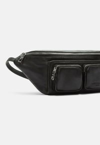 Bolso de cinturón de cuero negro con un diseño elegante, que presenta tres compartimentos con cremallera y un acabado texturizado. Forma compacta con un asa lateral.
