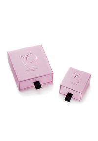 Dva ružové obdĺžnikové darčekové škatule s lesklým povrchom, s logom motýľa a čiernymi ťahacími páskami na otváranie. Jedna škatula je menšia ako druhá.