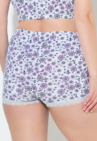 Bílé šortky s květinovým vzorem s fialovými a černými květy. Mají krajkový lem na spodním okraji, jsou vyrobeny z měkké a pružné látky.