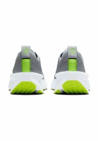 Zapatillas deportivas grises con una parte superior texturizada, acentos vibrantes en verde y una suela blanca gruesa con un dibujo en relieve para agarre.