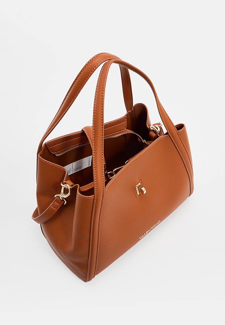 Sac à main en cuir brun à texture granuleuse, avec deux poignées supérieures, des accents en métal doré et un compartiment intérieur zippé. Il présente une silhouette structurée.