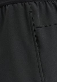 Zwart, glad stoffen met een lichte glans. Beschikt over een elastische tailleband en een zijzak met gestikte details.