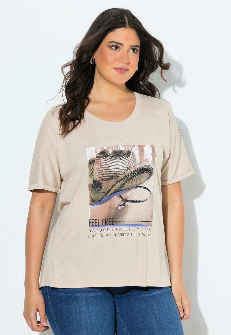 Camiseta beige de manga corta, con un gráfico de un sombrero y texto. Tela suave con un ajuste relajado y cuello redondo.