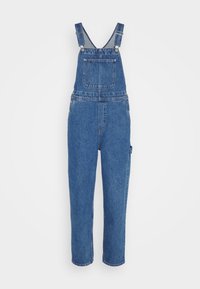 Salopette in denim di colore blu medio, con spalline regolabili, tasca frontale e tasche laterali. Vestibilità rilassata con gambe affusolate.