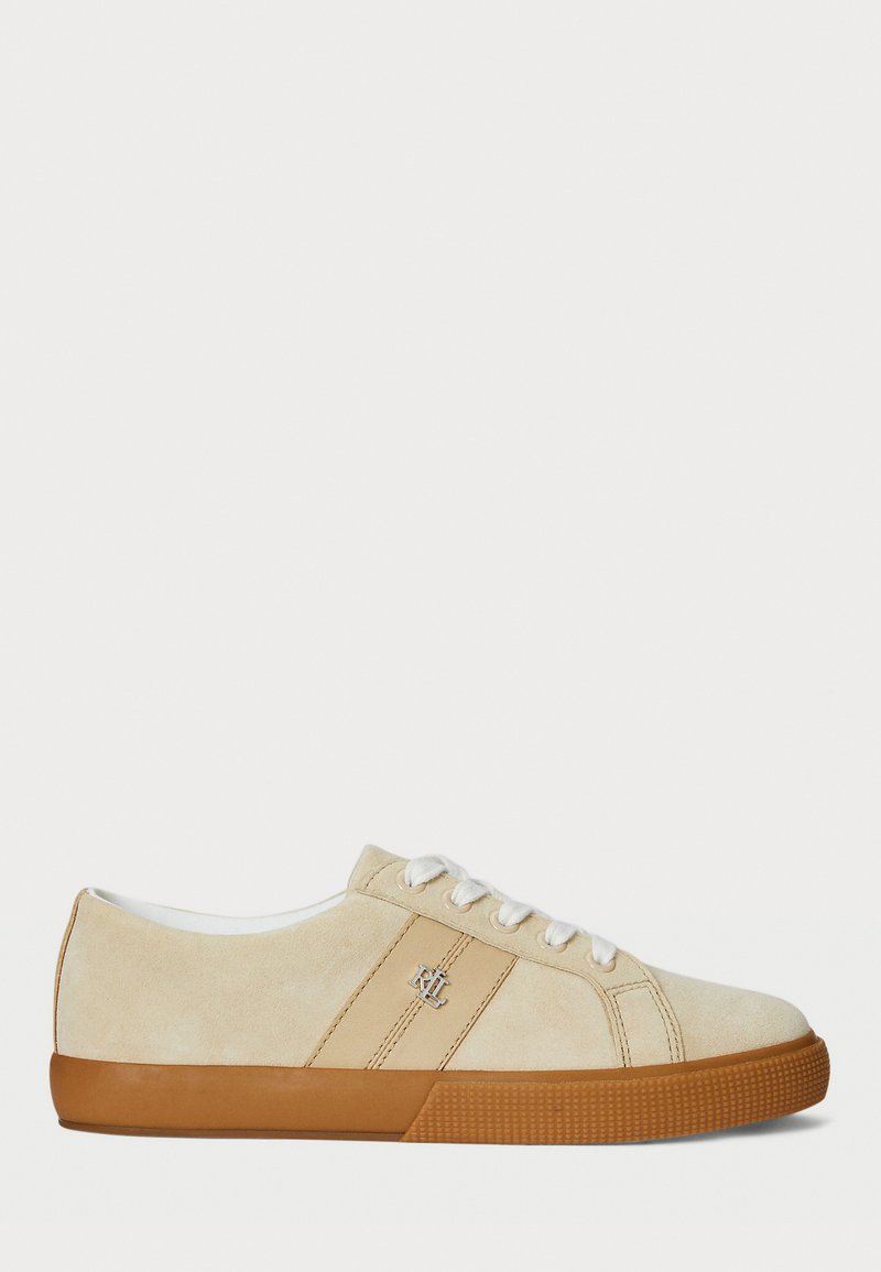 Beige suede sneakers with white laces and rubber gum sole. Feature a logo on the side and a smooth texture. Classic low-top design.