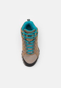 Chaussure de randonnée marron et beige avec des lacets turquoise et une doublure intérieure, dotée d'un tissu en mesh et d'une étiquette de marque Columbia sur la languette.