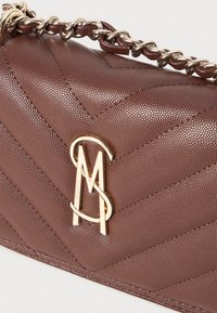 Bruine handtas met textuur en een chevronpatroon, gouden logoaccent en een kettingband. Gemaakt van synthetisch materiaal.