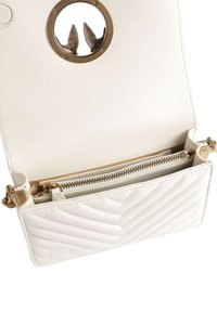 Borsa a tracolla in pelle bianca trapuntata con un accento in hardware dorato a forma di cerchio e tasca con zip, dotata di una fodera interna liscia.