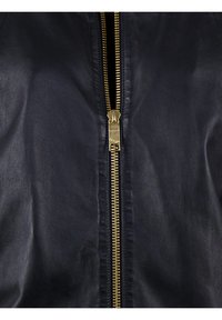 Marineblauwe leren jas met een gladde textuur, voorzien van een gouden metalen ritssluiting in het midden en subtiele stikseldetails langs de randen.