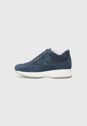 Blue suede sneaker with a textured mesh side panel and a white rubber sole. Features six eyelets for laces and a cushioned heel.