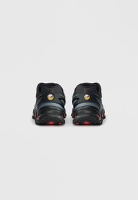 Czarne i szare buty sportowe z czerwonymi akcentami, widok od tyłu, z widocznymi logo Air Max w okolicy pięty.