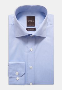 Ljusblå bomullsskjorta med spridd krage, knappslå och enkel knappmanschett. Har en twill-textur och en märkesetikett fäst.