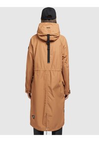 Parka impermeabile marrone con vita sfiancata, cappuccio e cintura nera sul retro. Presenta tasche laterali e una patch con logo vicino all'orlo.