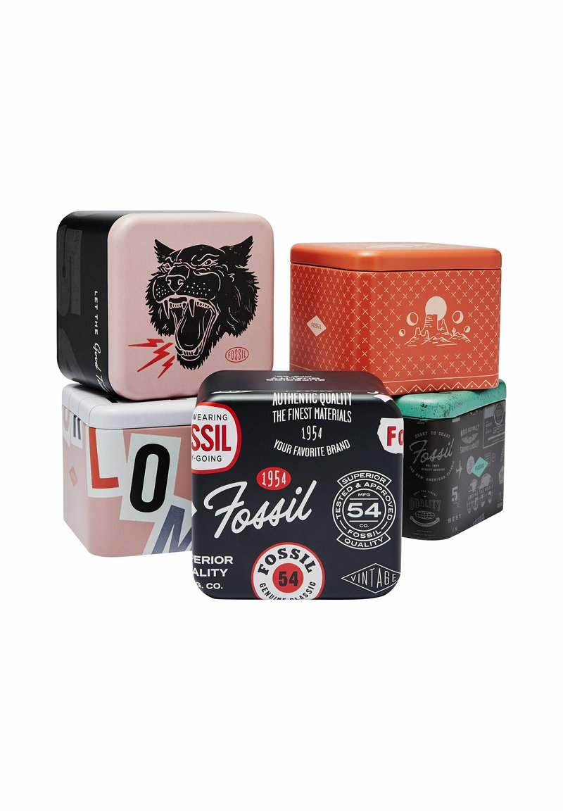 Cinco latas decorativas de almacenamiento de metal de la marca Fossil con diversos diseños gráficos y colores apiladas en una disposición escalonada.
