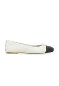 Ballerines en cuir blanc avec un embout en vernis noir, semelle plate et un petit nœud à l'avant. Texture lisse sur toute la surface.