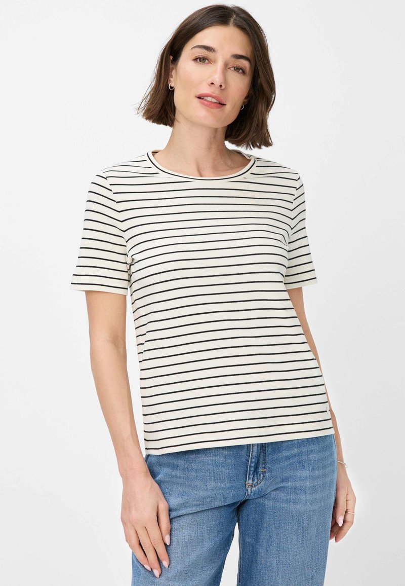 T-shirt a maniche corte di colore crema con strisce orizzontali nere, scollo rotondo, tessuto morbido, vestibilità casual, abbinato a jeans blu.