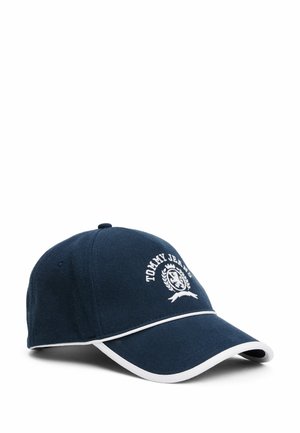 Granatowa czapka baseballowa z białymi detalami logo, białym wykończeniem wzdłuż daszka i teksturowanym materiałem. Ma zakrzywiony daszek i regulowane zapięcie z tyłu.