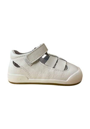 Zapato de cuero blanco con una correa de velcro, lados abiertos, punta redondeada y suela texturizada. Presenta un sutil logotipo en la correa.