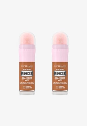 Maquillage 4-en-1 Glow de Maybelline. Capuchon rose avec un applicateur doux, et un corps cylindrique beige avec une étiquette produit indiquant la teinte 03 Medium Deep.