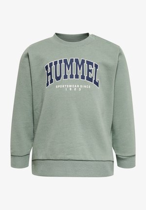 Grön sweatshirt med ribbad rund halsringning och långa ärmar. Har mörkblå "HUMMEL" text och "SPORTSWEAR SINCE 1923" i vitt.