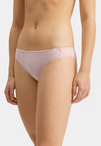 Różowe bawełniane bikini o gładkiej fakturze, z małym akcentem w postaci kokardy na pasku i metką z logo po boku.