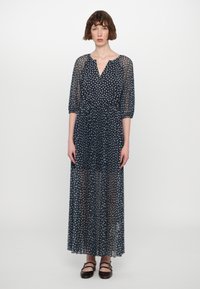 Mørkeblå maxi-kjole med gjennomsiktige lange ermer, blomstermønster, V-hals og elastisk midje, avsluttet med et flytende, lett stoff.