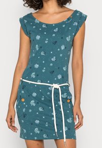 Turkusowa sukienka wykonana z bawełny, z krótkimi rękawami, okrągłym dekoltem i białym sznurkiem w talii. Ozdobiona wzorami przedstawiającymi życie morskie oraz guzikami.
