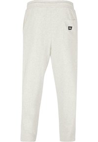 Light gray sweatpants with a relaxed fit, elastic waistband, and a single back pocket featuring a black logo patch. Soft cotton blend material.