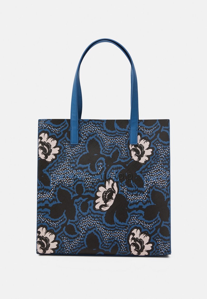 Sac cabas bleu et noir à motif floral avec des fleurs rose clair et de longues anses bleues, présenté sur un fond uni.