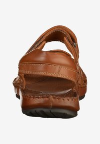 Brown leather sandal with an open back, adjustable strap, stitched detailing, and a textured insole. Flexible rubber outsole for traction.