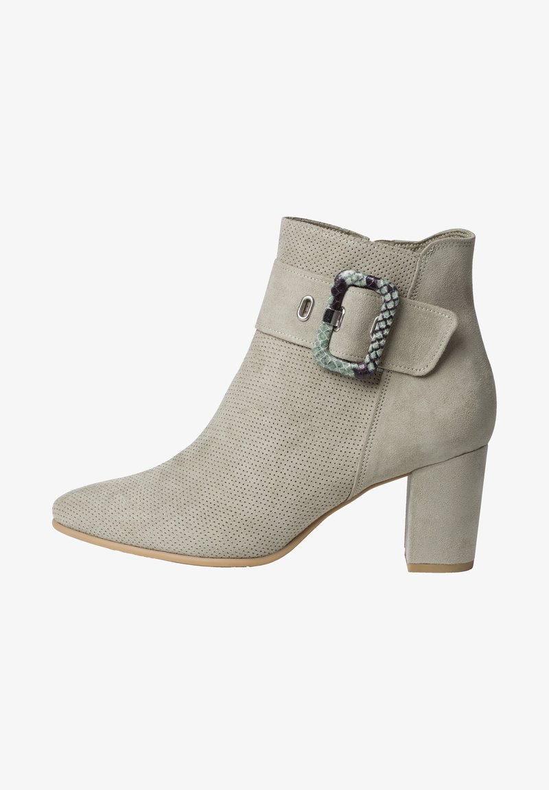 Beige Wildleder-Stiefelette mit einem durchbrochenen Obermaterial, breitem Blockabsatz und einer dekorativen Schnalle mit einem Akzent in grün-schwarzem Schlangenmotiv.
