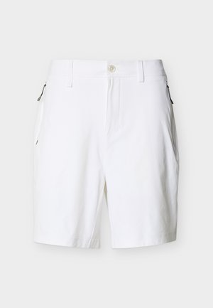 Bijele krojene kratke hlače s petljama za remen, prednjim gumbom i zatvaračem, te bočnim džepovima na patentni zatvarač na jednobojnoj pozadini.
