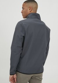 Men's dark gray jacket with a high collar, smooth texture, slim fit, and contrasting black trim along the hem and sleeve cuffs.