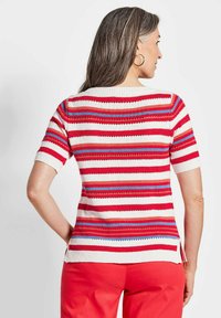 Korte mouw gebreide top met horizontale strepen in rood, wit en blauw. Geribbelde halslijn en zijsplitten aan de onderrand. Katoenmix materiaal.