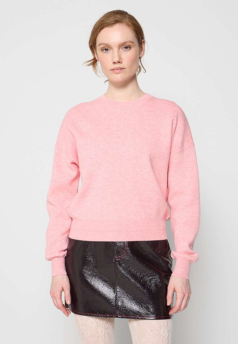 Roze crewneck sweatshirt met ribbelmanchetten en -zoom, gedragen over een glanzende zwarte minirok. Lichtgewicht stof met een zachte textuur.